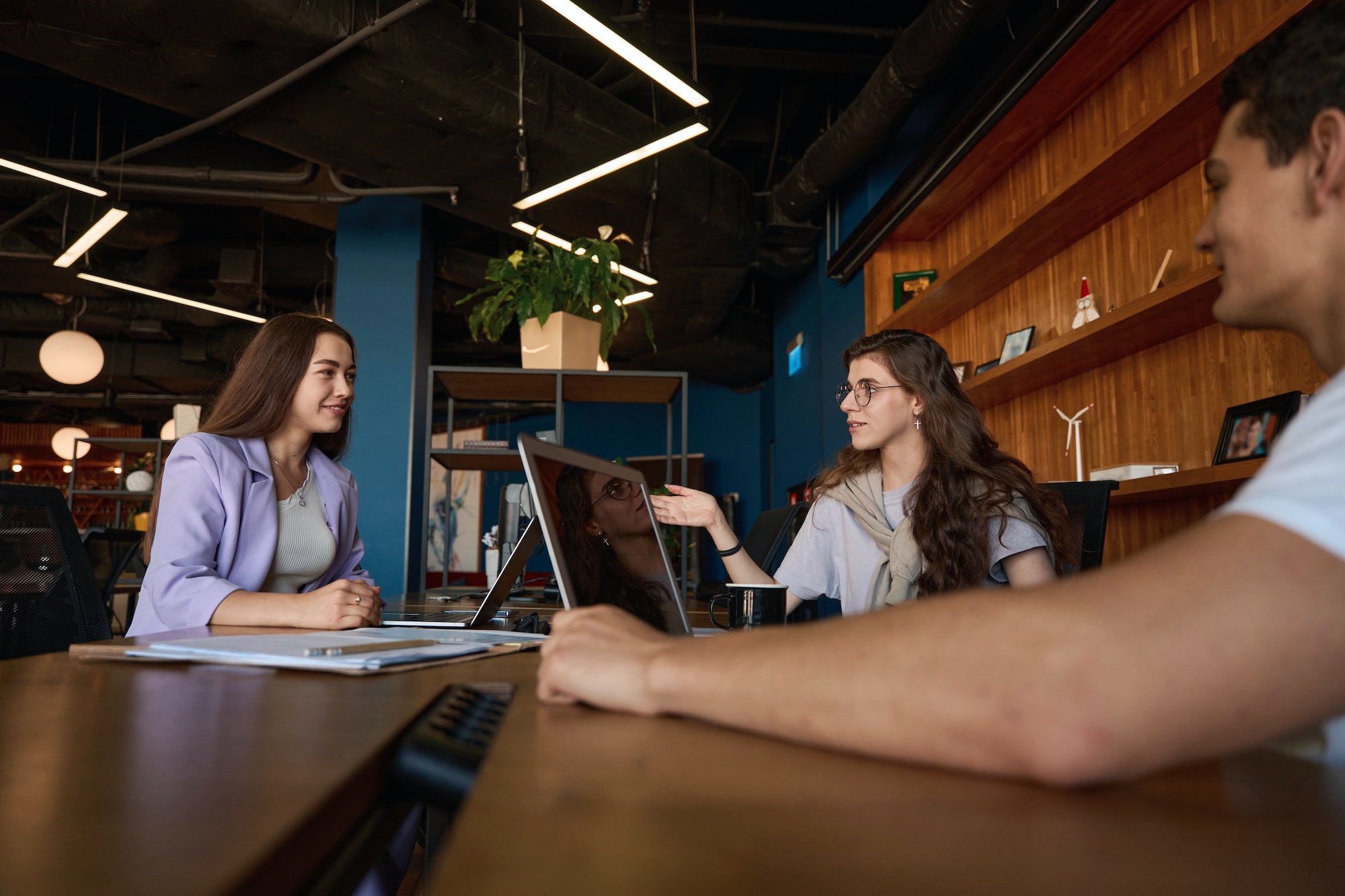 Friendly office team discussing workflow at a large table in the office