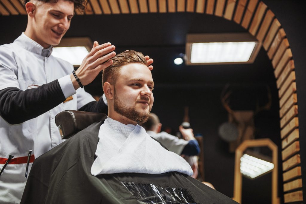 Men's hairstyling and haircutting in a barber shop or hair salon.